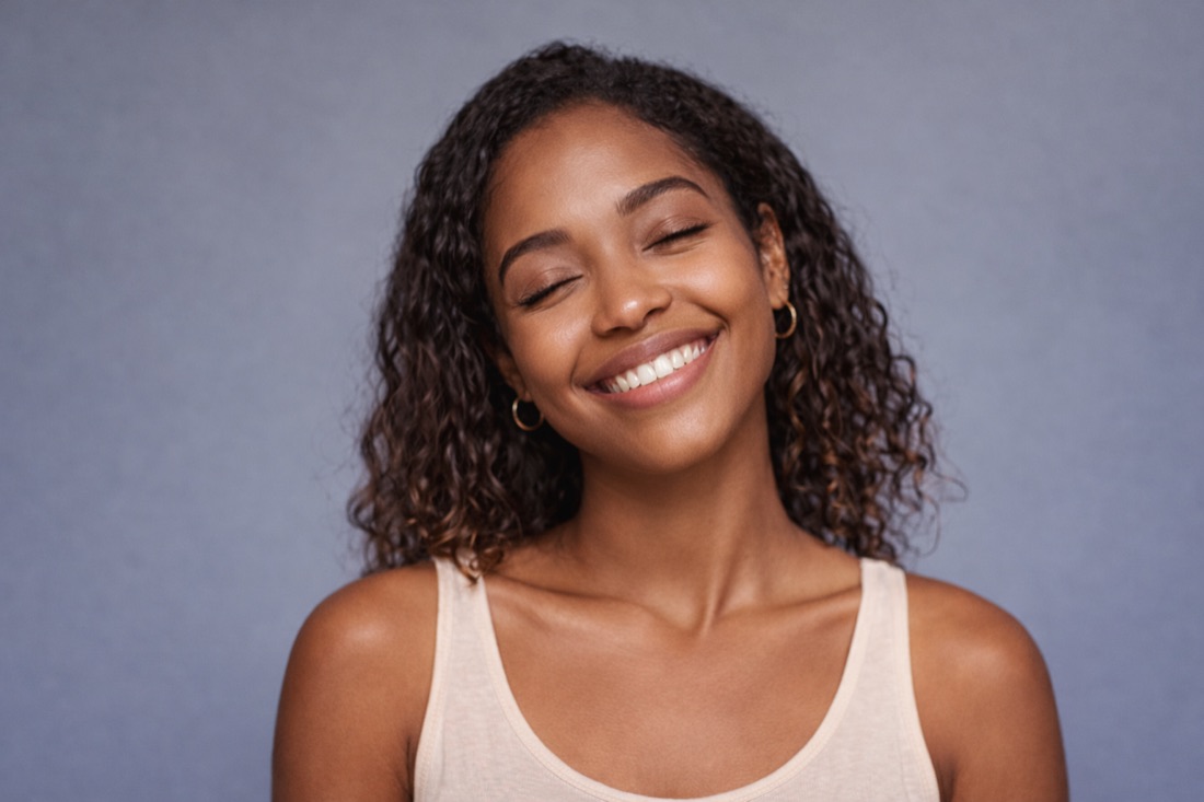 A smiling woman with her eyes closed